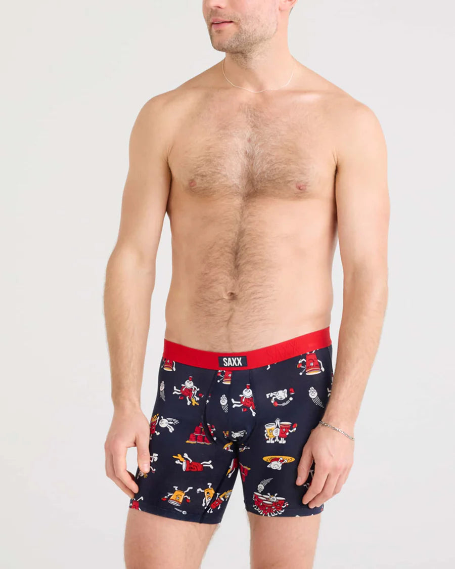 Man wearing navy boxer briefs with red waistband and cartoon designs on a white background