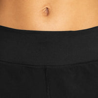 Close-up of a person wearing black pants with a neutral background