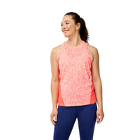 Woman wearing a pink sleeveless top and blue leggings on a gray background