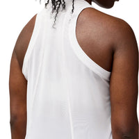 Person wearing a white sleeveless top against a plain background