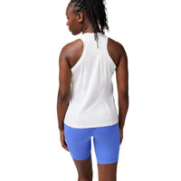 Person wearing a white tank top and blue shorts on a plain background