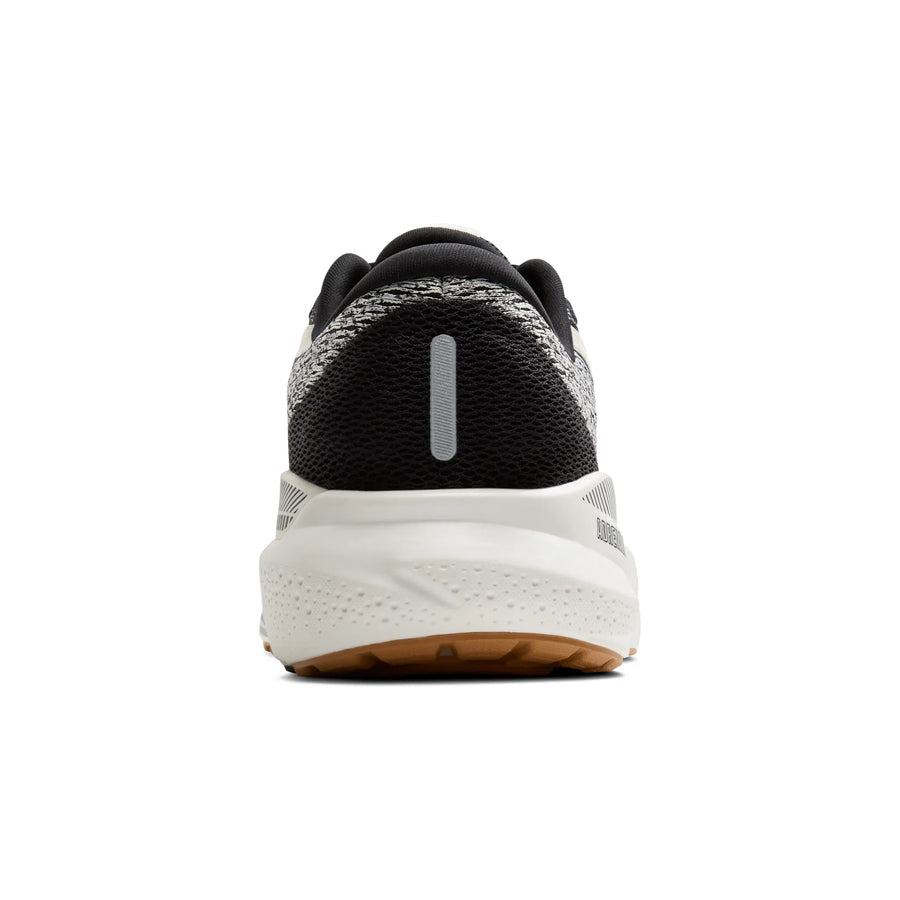 Black and white running shoe with a visible brand logo on a white background