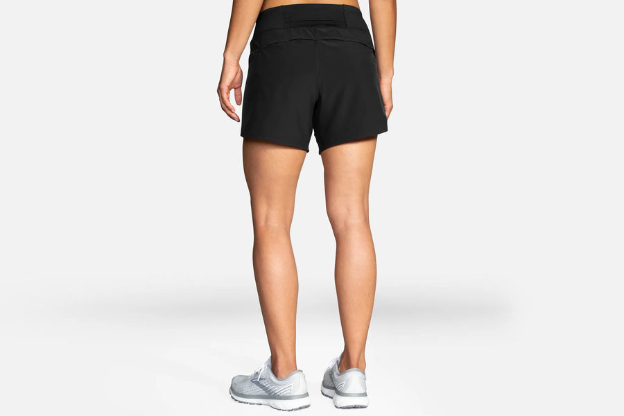 Person wearing black athletic shorts on a white background