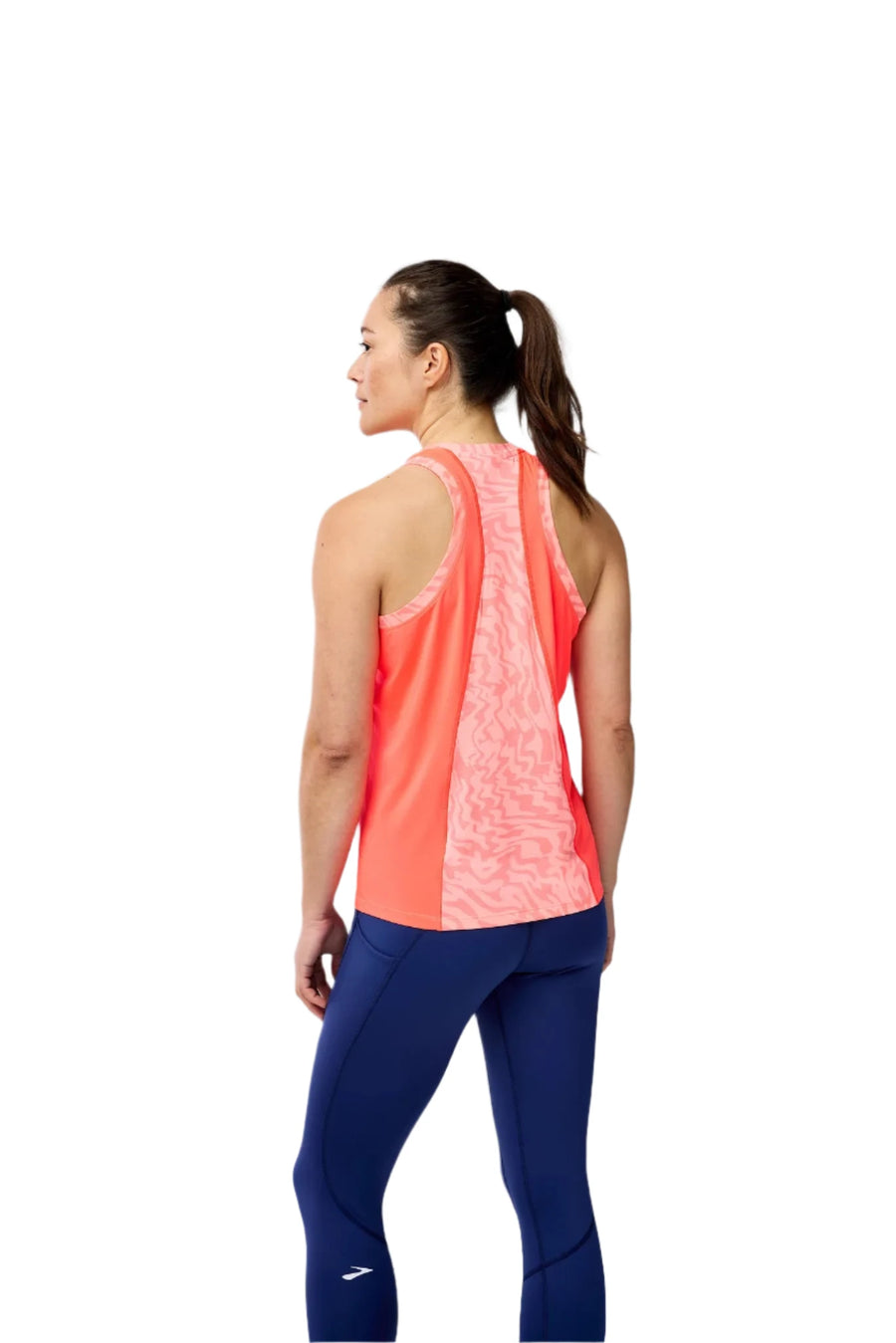 Woman wearing a pink and blue athletic outfit on a gray background