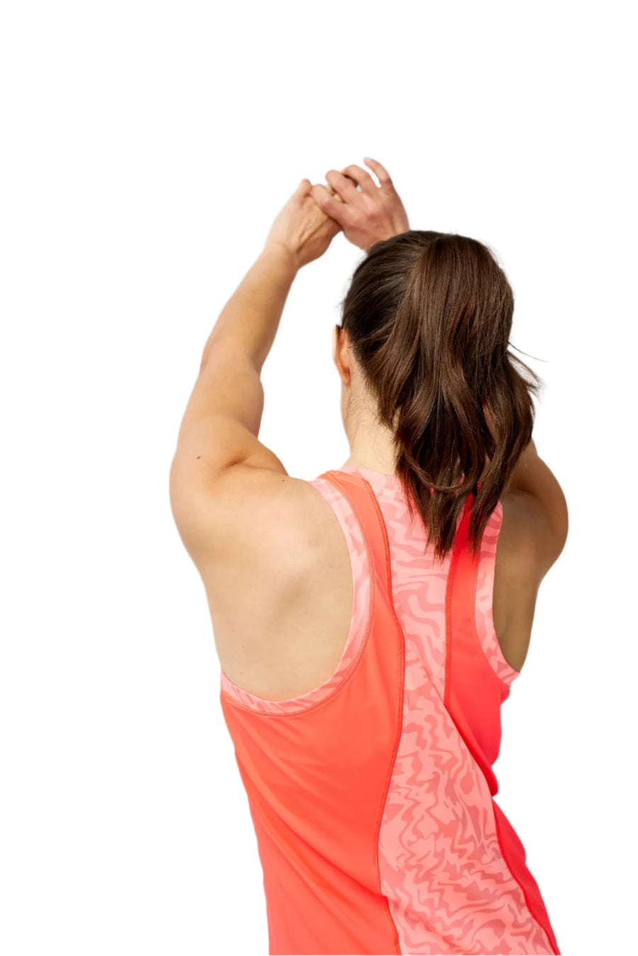 Woman in a coral tank top stretching against a gray background