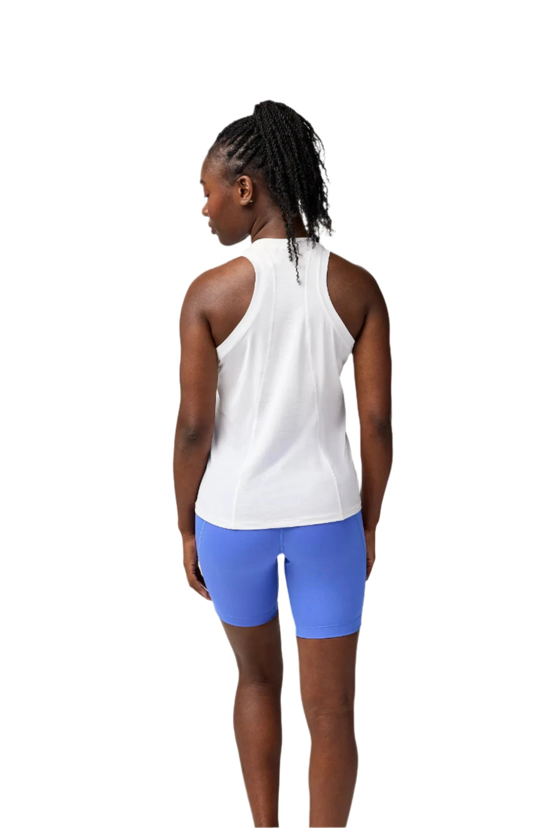 Person wearing a white tank top and blue shorts on a plain background
